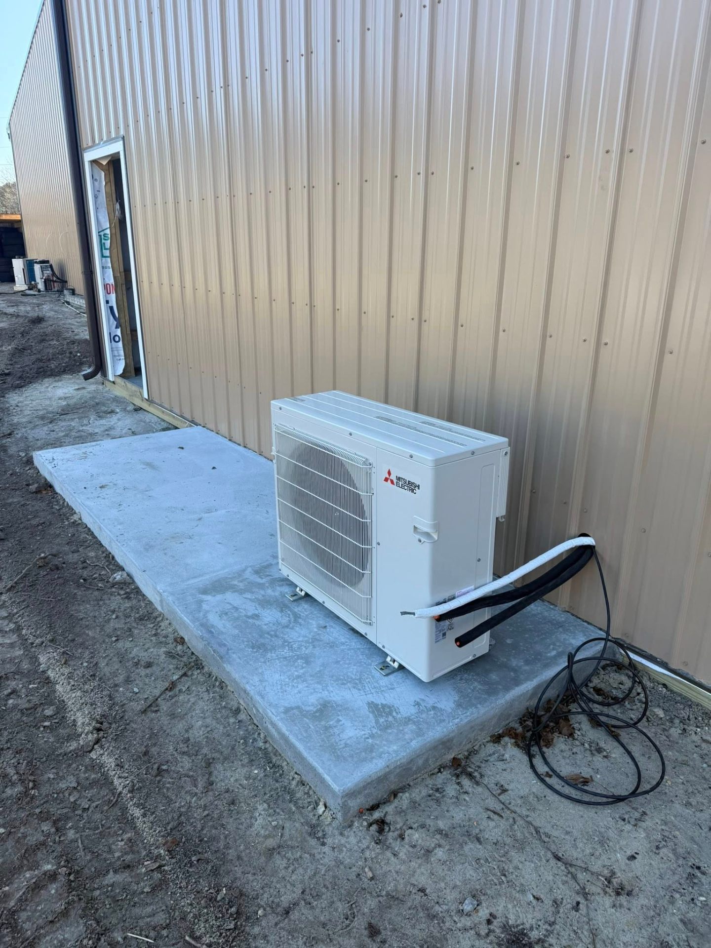 Mitsubishi condenser on concrete pad at commercial building