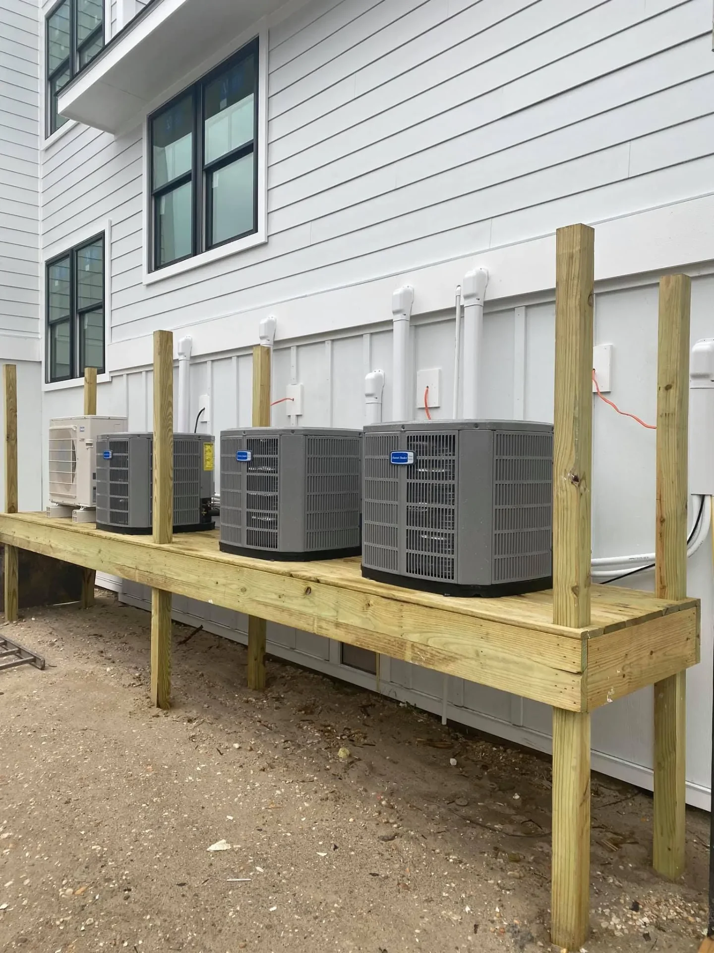 Four AC condensers on elevated wood platform